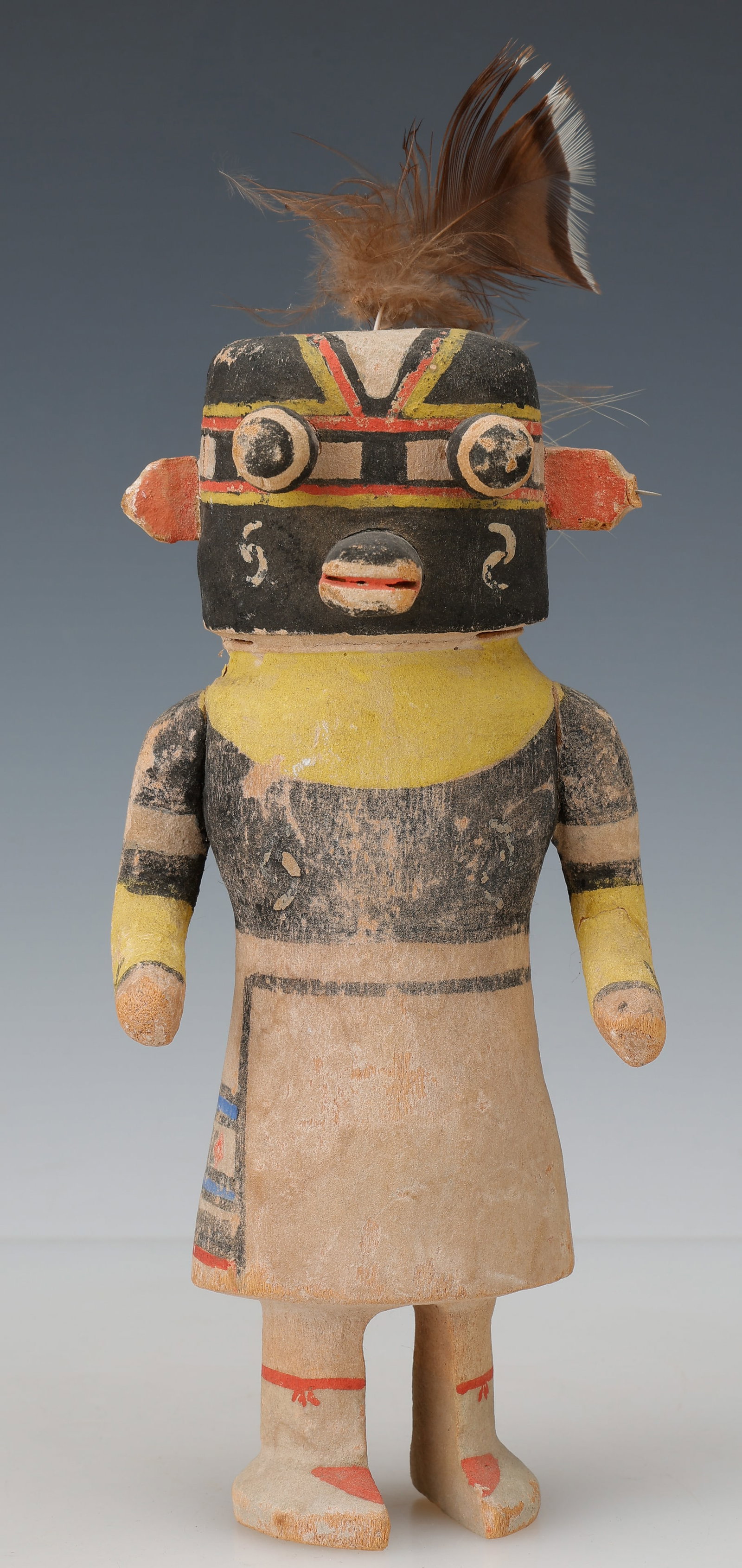 Antique Hopi Heheya Kachina Doll, Early 20th C., H: 9": Antique Hopi Heheya Kachina Doll, Early 20th C. Carved wood with pigments and feather elements. With cylindrical black mask, projecting ear forms, painted geometric facial decoration, and feather cres