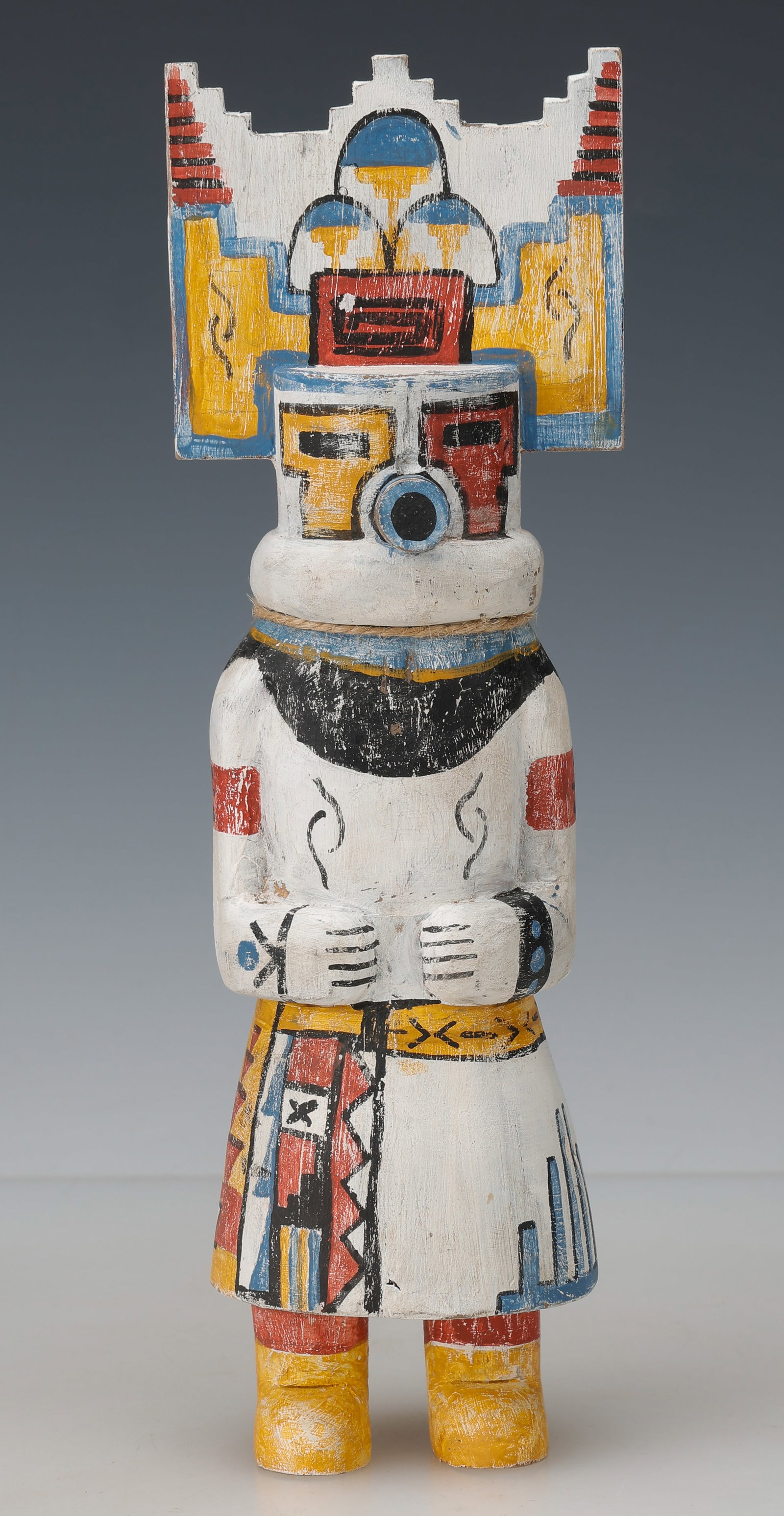 Hopi Hemis Kachina Doll, Mid-20th C., H:10.5": Hopi Hemis Kachina Doll, Mid-20th C. Carved wood, pigment. Hemis-style dancer with stepped tablita headdress, cylindrical mask form, and geometric painted costume decoration. Size: 10.5'' x 3'' x 2.5'