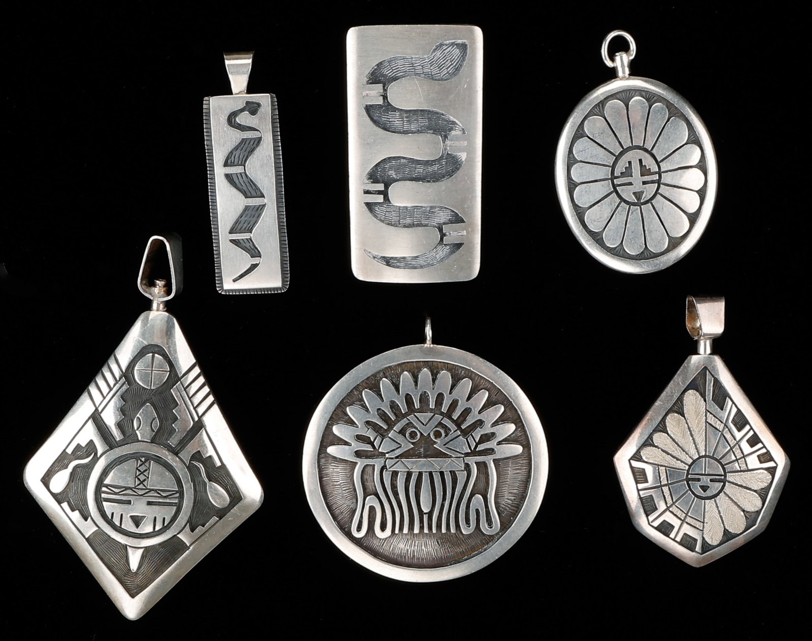6 Hopi Silver Pendants, Weight: 131g: 6 Hopi Silver Pendants. Including: 3 stamped with a signature 1) "R.K."; 2) "F.P."; 3) "N" with added symbol and Sterling. Sizes From: 2'' x .5'' (5 x 1 cm); To: 3'' x 2'' (8 x 5 cm). Weight: 131g.