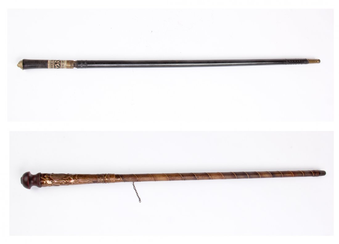 Two Walking Stick Swords: Two Walking Stick Swords. One made of wood with bone and metal fittings. The other made of wood and clad in chase metal sheeting. Size: 36" x 1" x 1" (longer).
