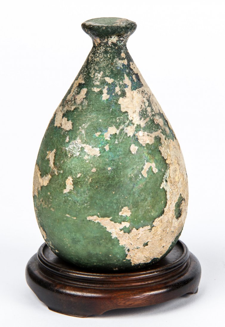 Islamic Iridescent Glass Vessel/Unguentarium: Islamic Iridescent Glass Vessel/Unguentarium; with a golden patina over a green core, 10th-12th century CE. Size: 7" x 4" x 4" (18 x 10 x 10 cm). Provenance: Philadelphia lady.