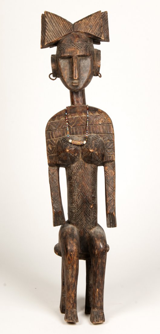 African Carved Wood Shango Figure: African Carved Wood Shango Figure. Embellished with metal earrings and pendant gorget. Size: 34" x 8" x 5", (86 x 20 x 13 cm). Provenance: Suburban Philadelphia collection.