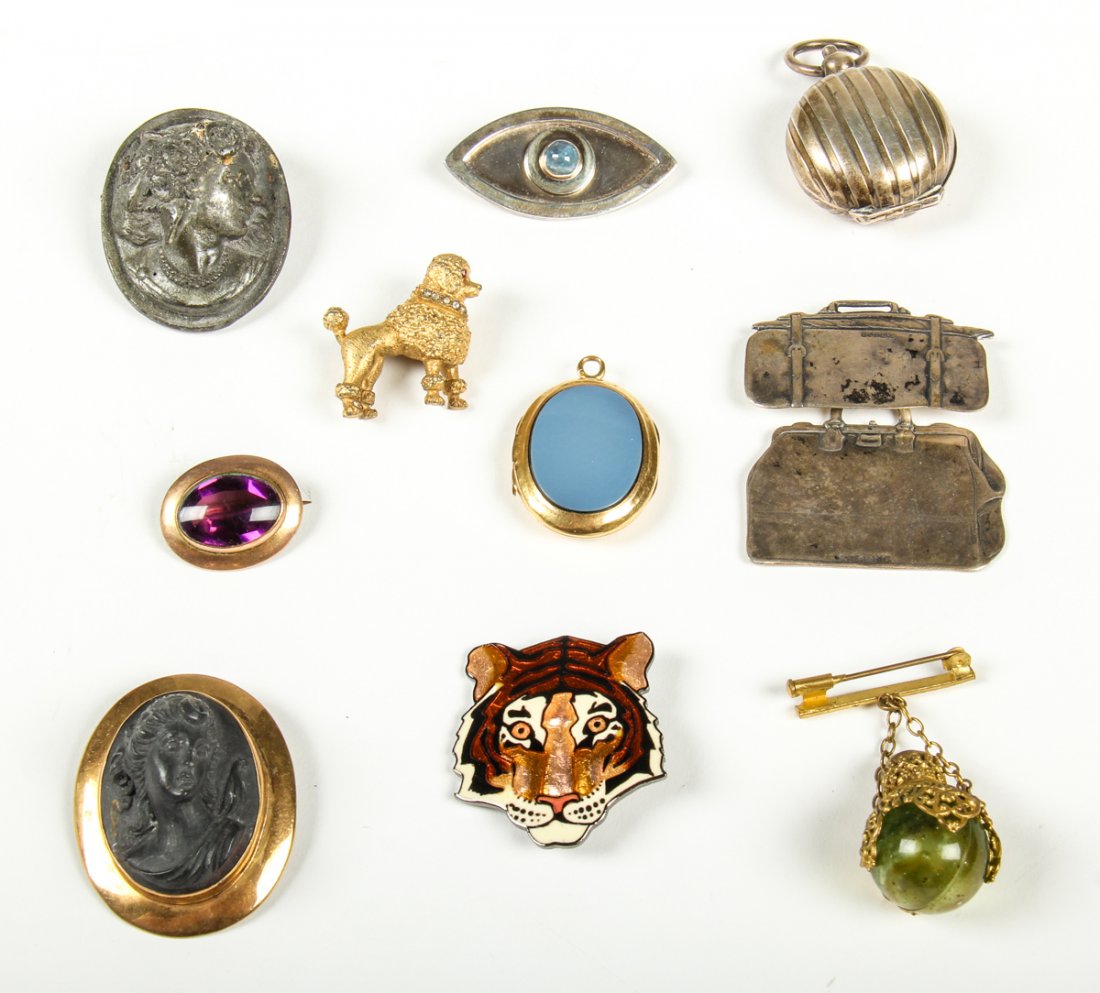 Estate Lot of 10 Brooches and Lockets: Estate Lot of 10 Brooches and Loockets. With two pins including a gold filled lava cameo, and a gold filled cabochon simulated purple stone pin. An 18k yellow gold locket with light blue enamel plaque