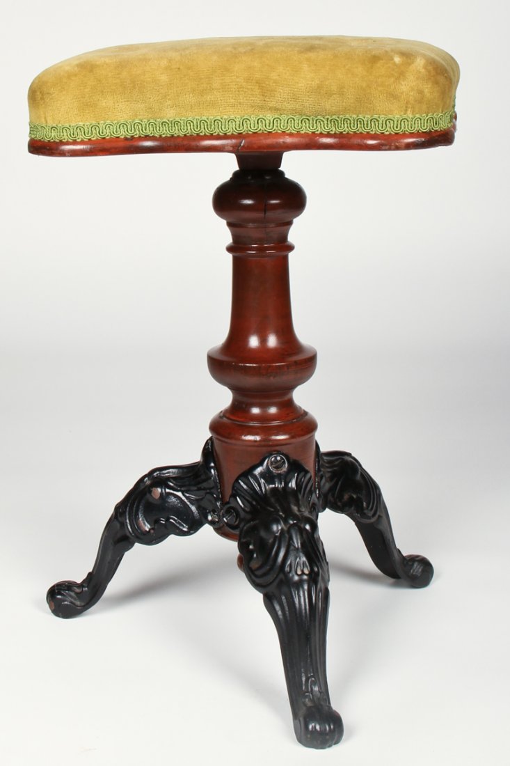 Victorian Piano Stool: Victorian Piano Stool. Crushed velvet seat atop a turned walnut shaft on tripod cast iron legs. Size: 20" x 12" x 12" (51 x 30 x 30 cm).