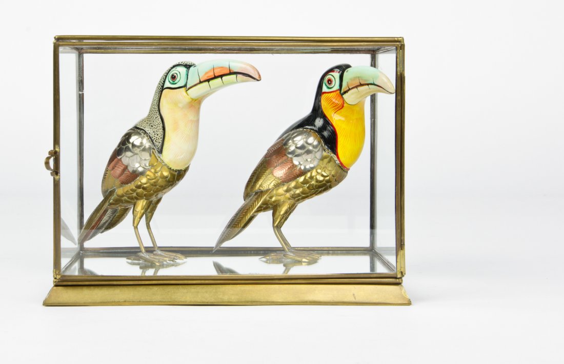 Metal Toucans in the Style of Sergio Bustamante: Painted metal Toucans in the style of Sergio Bustamante. In a glass box. Signed Carlos del Conde. Dated '08 and '05. Size: 5.5" x 6.5" x 3.5", 14 x 17 x 9 cm (each).