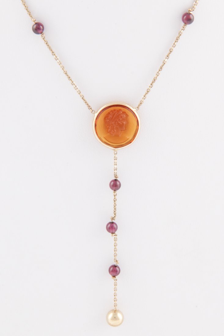 14K Gold, Amethyst and Carnelian Necklace: Gold, Amethyst and Carnelian Necklace. Gold Chain marked 14K with Amethyst Beads terminating at a Bezel-set Carved Cameo further suspending Drop with more Amethyst Beads and Gold Ball Pendant. 16"L (4