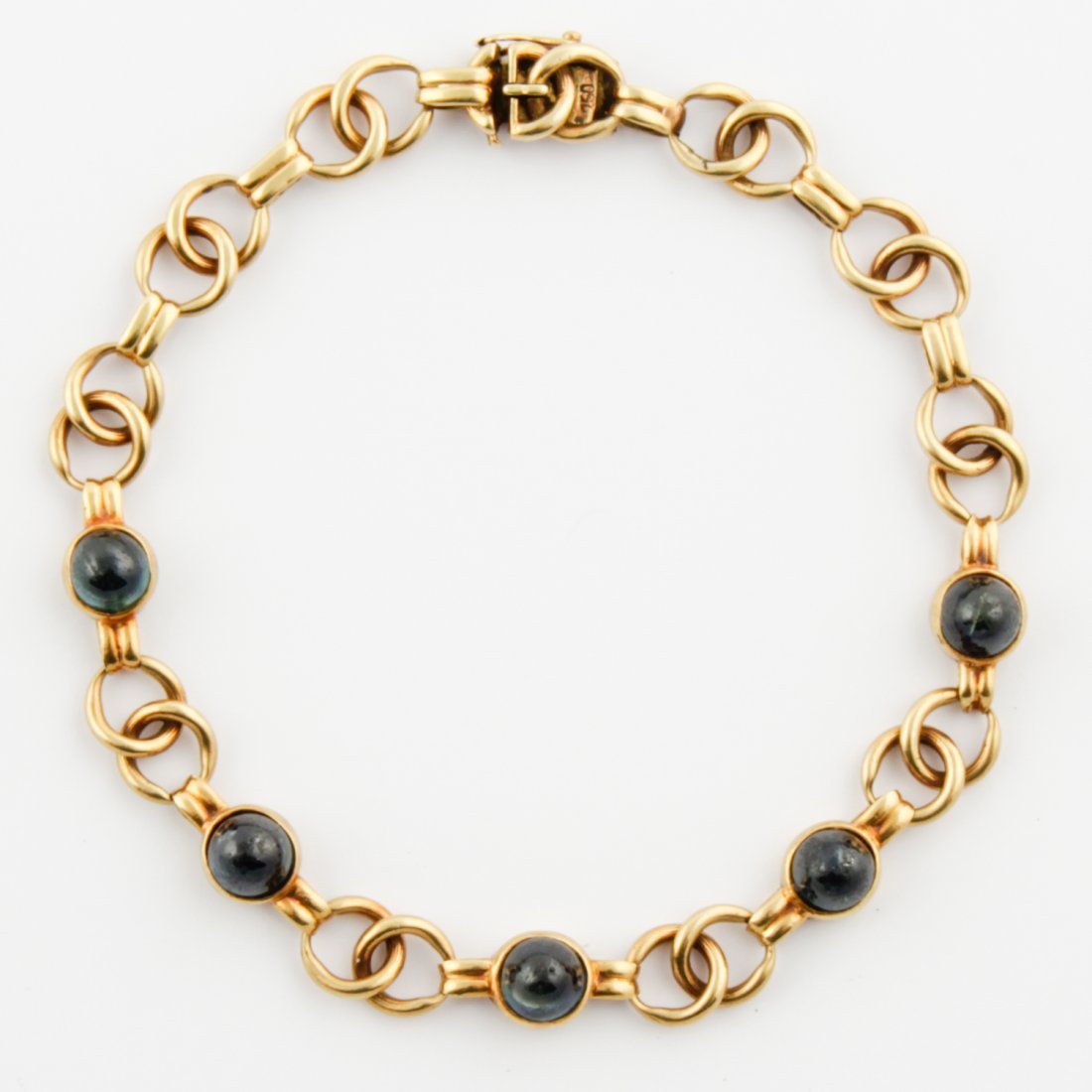 18K Gold and Sapphire Bracelet: Gold and Sapphire Bracelet. Sugarloaf Sapphires set in Bezels and connected to 18K Yellow Gold Bracelet marked 750. 8"L (20 cm). 16.2 g.Since 1937, the The Silver Shop of Princeton, NJ was located at