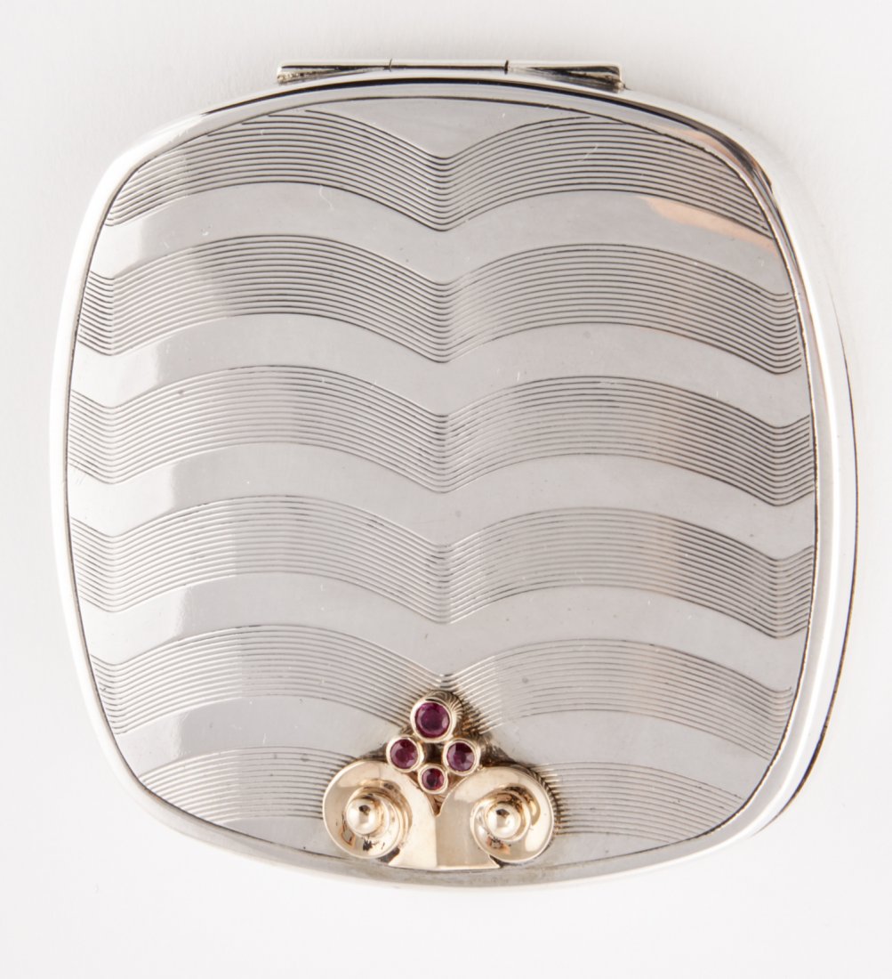 Silver, Gold and Ruby Compact, 1940s: Silver, Gold and Ruby Compact. 1940s Case with Wave Pattern Engraved to top and Collet-Set Rubies to form Fountain Motif. Marked Sterling 14K. 2.75"Sq. 3.76 ozt. Since 1937, the The Silver Shop of Pri