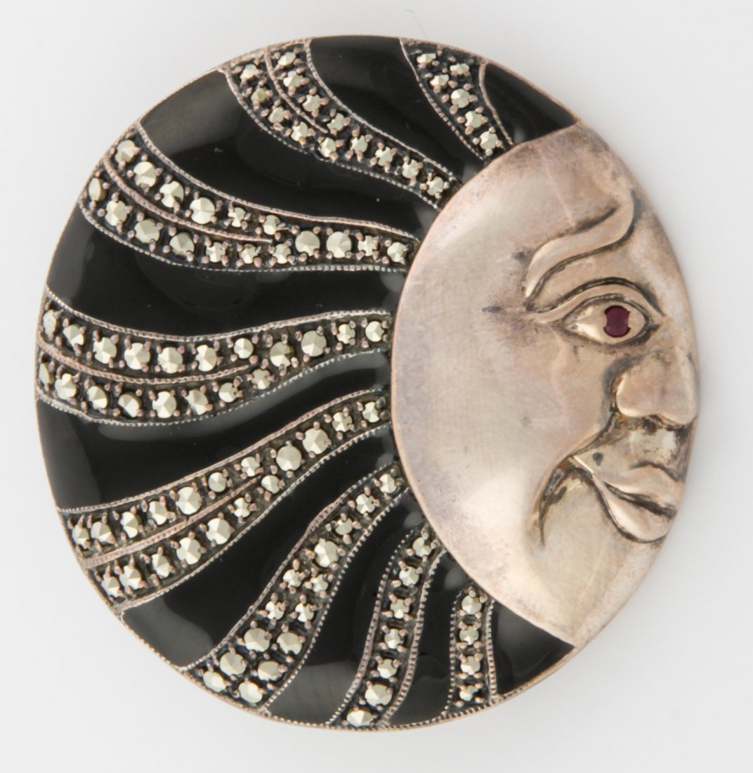 Sterling Marcasite Brooch Depicting the Man in the Moon: Exciting Sterling Marcasite Brooch depicting the Man in the Moon. Rows of Enamel and Stones flowing from the pleasing Face set with a Ruby in the Eye. Size: 1.25"D (3 cm). 24.6 g. Since 1937, the The 