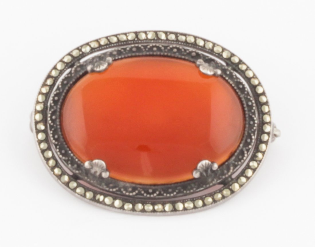 Antique Silver, Carnelian and Marcasite Brooch: Antique Silver, Carnelian and Marcasite Brooch. Beautiful Oxidized Silver Oval Pin with Carnelian Plaque in a Marcasite surround. Marked Sterling. Size: 1.25" x 1" (3 x 2.5 cm). 7.8 g. Since 1937, the