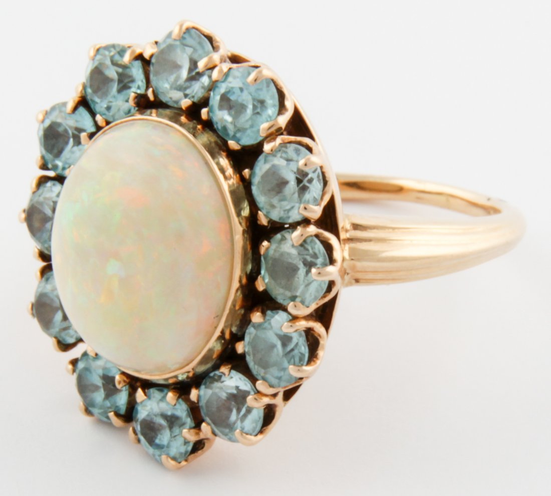 14K Gold, Zircon and Opal Ring: Gold, Zircon and Opal Ring. Bezel-set Opal surrounded by Blue Zircons on Gold Ring marked 14K. Size 5. 6.2 g. Since 1937, the The Silver Shop of Princeton, NJ was located at 59 Palmer Square West.