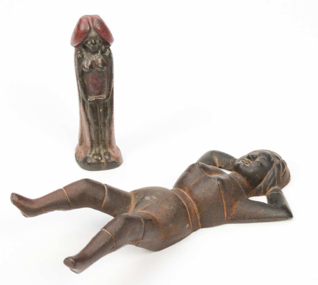 Group of 2 Naughty Cast Iron Implements: Group of 2 Naughty Cast Iron Implements. Consisting of a Naughty Nelly Bootjack and anthropomorphic phallis. Size: 5.5" x 1.5" x 1.5" (14 x 4 x 4 cm) and 2" x 9.5" x 4" (5 x 24 x 10 cm).