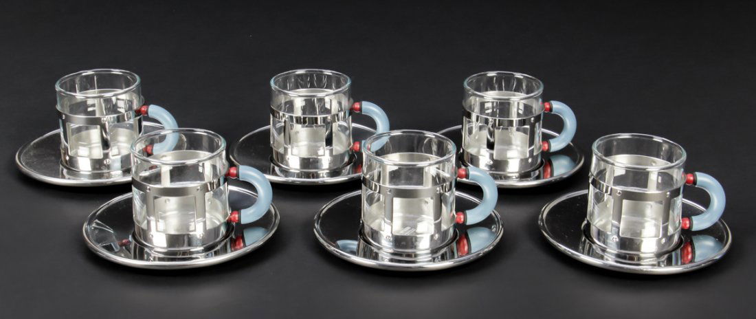 Set of 6 Alessi Mocha Cups and Saucers, by M. Graves: Set of 6 Alessi Mocha Cups and Saucers, Designed by Michael Graves, stainless steel and glass. Size: 4.75"D, 12 cm (saucers) and 2.5" x 3.5" x 2.25", 6 x 9 x 6 cm (cups).