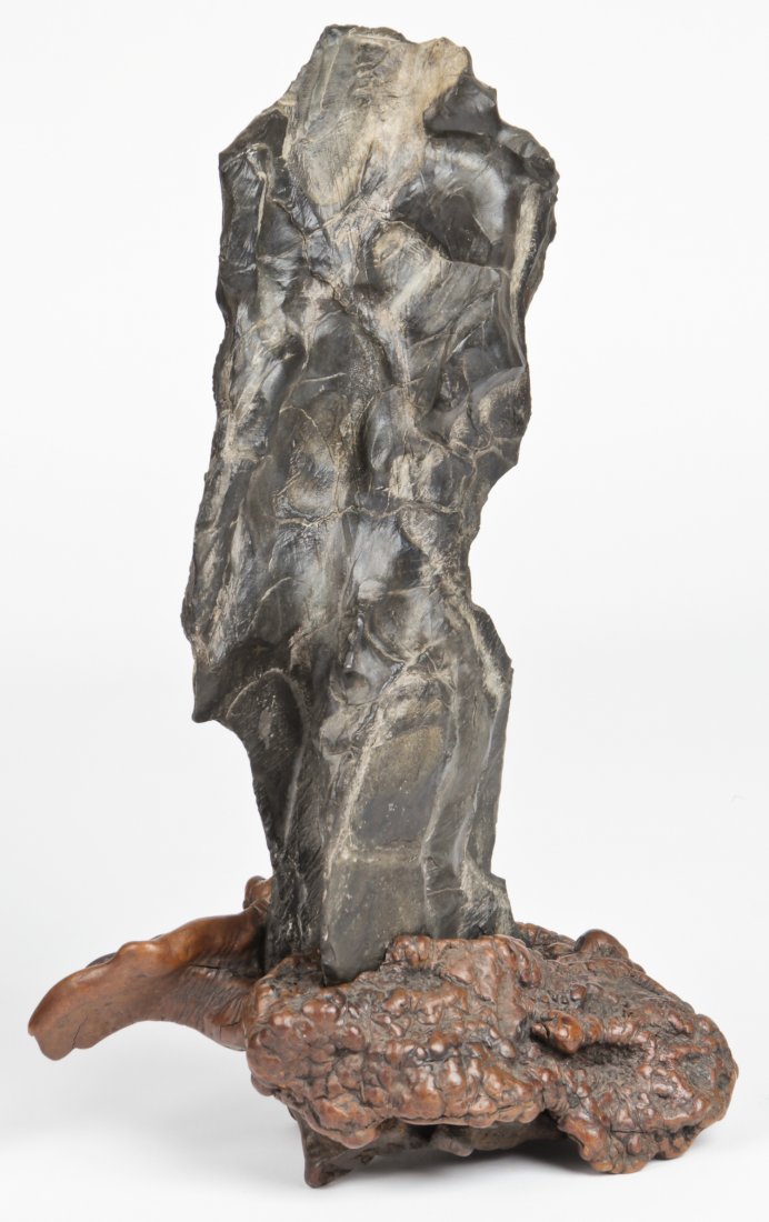 A Chinese Lingbi Scholar's Rock: A Chinese Lingbi scholar's rock on burlwood stand. 19th / 20th century. Size: 21.5" x 13" x 8" (55 x 33 x 20 cm). Provenance: Estate of Robert Swan Lindsley and Eric Hoage, Philadelphia.