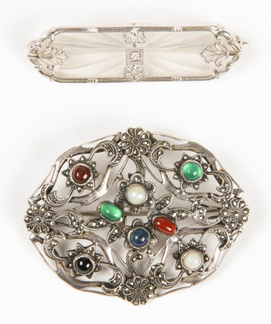 2 Estate Jewelry Brooches: 2 Estate Jewelry Brooches. The first an Art Deco carved rock crystal in a bezel frame marked 10K. The second a filigree sterling rosette set with marcasite and semi precious stones. Largest Size: 1.5"