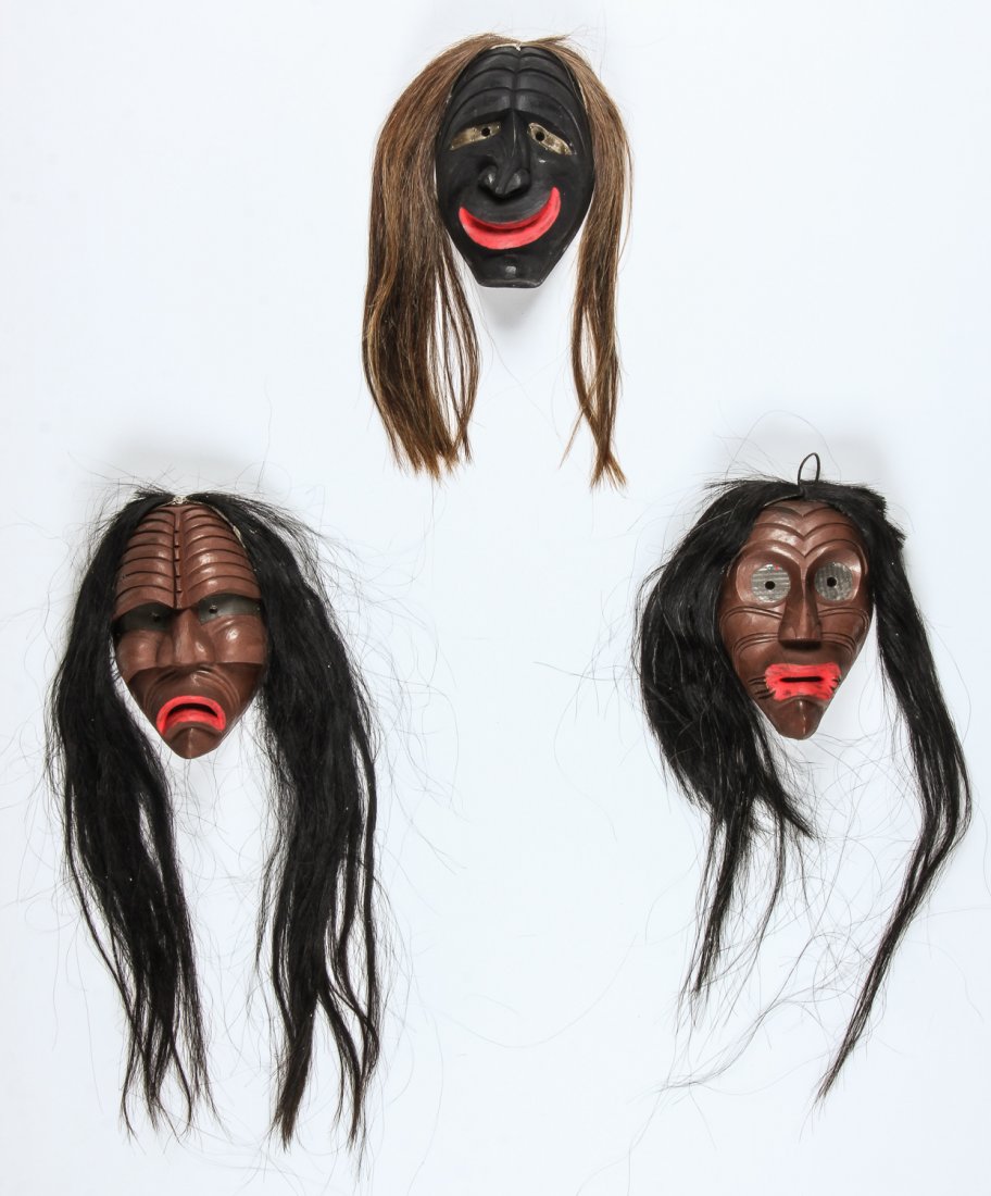 Group of 3 False Face Masks: Group of 3 False Face Masks, carved and painted wood with hair. Largest Size: 12" x 7" x 5" (30 x 18 x 13 cm).