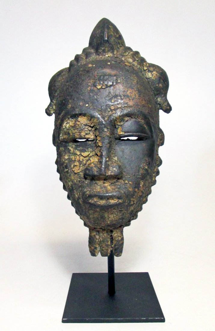 Old Baule Portrait Mask, West Africa: Old Baule Portrait Mask, West Africa; carved wood mask with heavy sacrificial patina suggesting use as a shrine object. Size: 12" x 7" (30 x 18 cm). Includes base.