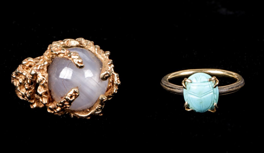 2 Estate Jewelry Rings: 2 Estate Jewelry Rings. Consisting of a moonstone set in a slag gold setting marked 14k and weighing 10.67 dwt, and a turquoise scarab prong mounted wooden ring that is foil lined. Ring sizes ranging