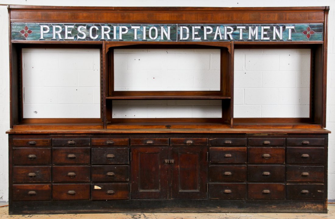 Massive Antique Apothecary "Prescription Department": Massive Antique Apothecary "Prescription Department" Pharmacy Counter, complete with fully restored period stained-glass. 2 central cabinets surrounded by 26 drawers. Size: 90.5" x 141" x 24.5" (fixtu