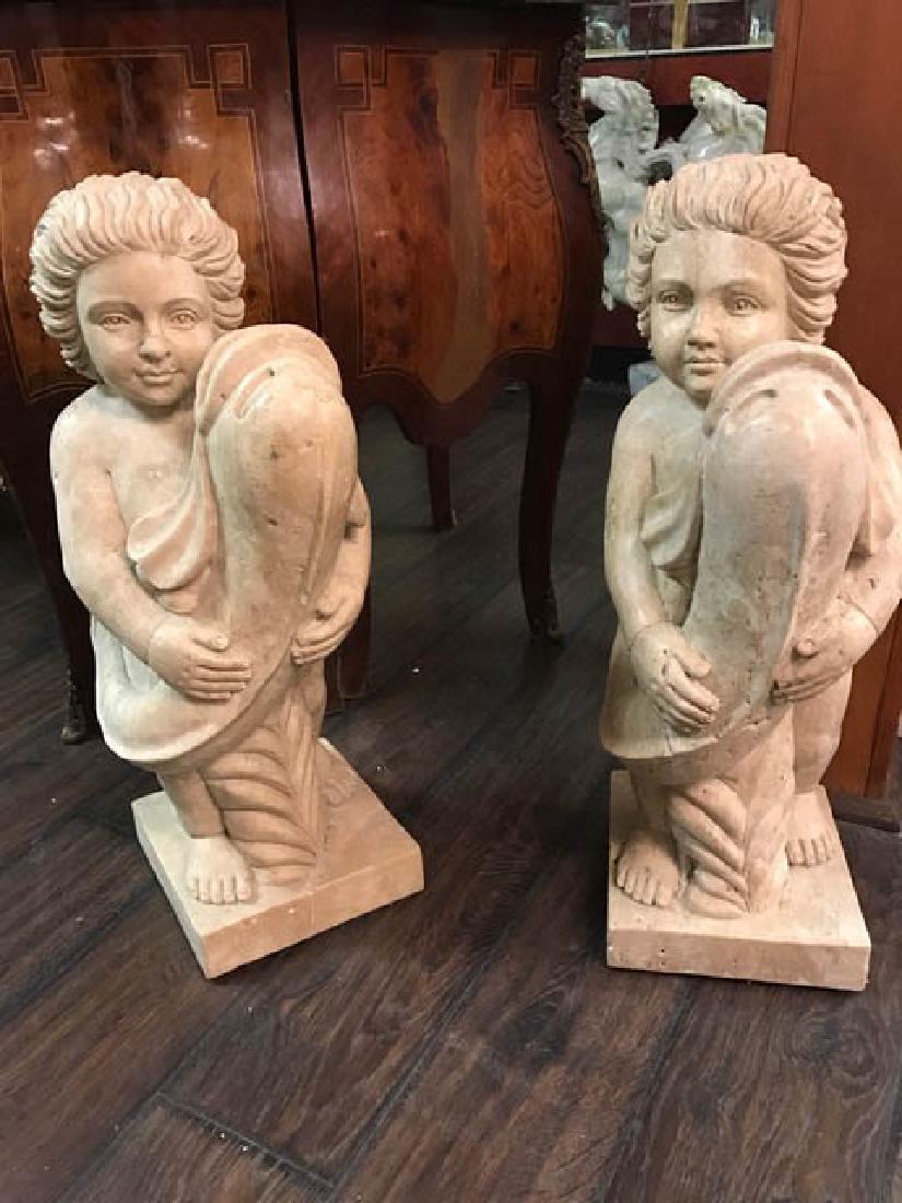 Pair of Carved Marble Statues of Boy Holding Fish: Pair of solid travertine colored marble statues each of a boy holding a fish. Very detailed carved out of one solid piece of marble. From a private collection. Measures approx. 24" H x 8" W x 8.5" D