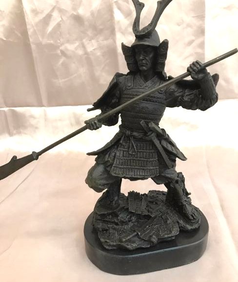 Bronze Statue of a Samurai Holding a Spear: Very detailed bronze statue of a samurai holding a spear and a bottle. Mounted on a smooth onyx base with black felt on the bottom. From a private collection. Measures approx. 11" H x 12" W x 4.5"D.