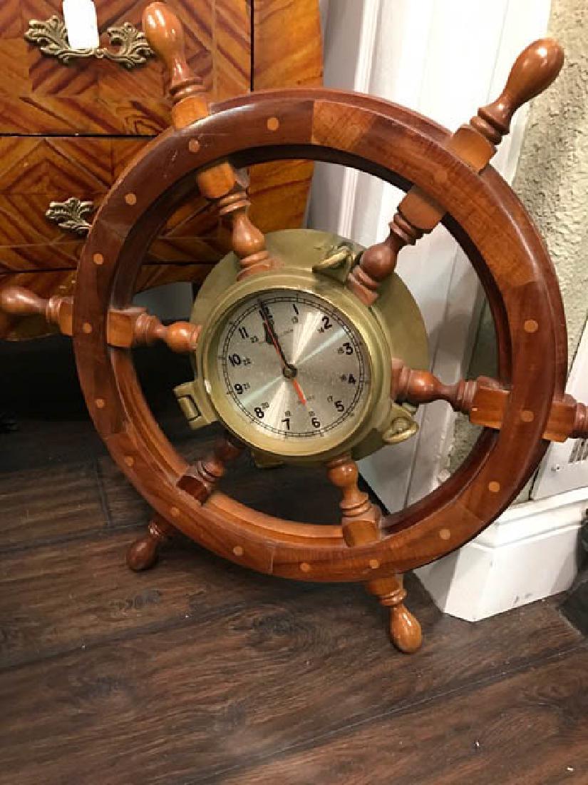 Maritime Wheel Clock: Maritime wheel clock with brass accents. Can be hung on the wall. Shows some wear, overall in good condition. Measures approx. 24" diameter.