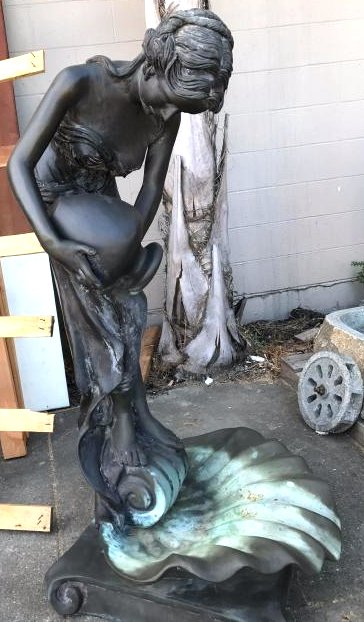 Bronze Fountain of Woman Pouring Water Into Shell: Bronze dual-patinated fountain of woman pouring water from a jug or water vessel into a shell. Signed, "Chrlier." Has good details and is in good condition. Measures approx. 55"H x 27"D x 26"W.