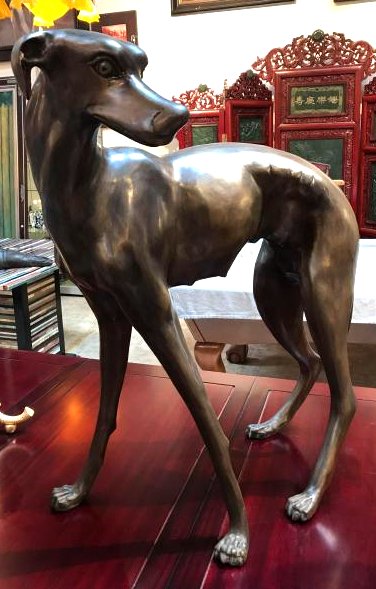 Bronze Statue of Female Greyhound Dog: Bronze statue of a female greyhound dog standing. In excellent condition. Measures approx. 32"H x 24"W x 16"D.