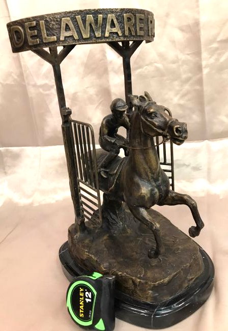 Bronze Statue of "Delaware Park" Racehorse: Bronze statue depicting the start of a "Delaware Park" horse rack with jockey. Gate on each side moves. Mounted on a solid black marble base. Great details From a private collection Measures approx. 1