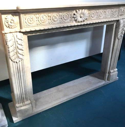 Exceptionally Carved Marble Fireplace: Exceptionally carved travertine colored marble fireplace with leaves and flowers design. Measures approx. 46.5"H x 66"W x 15"D.
