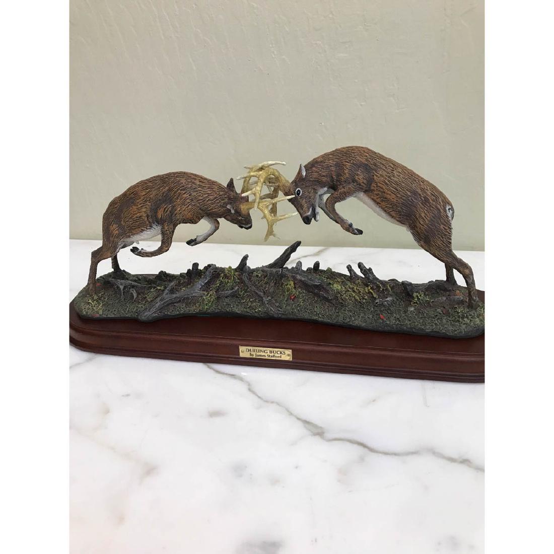 "Dueling Bucks" Buck Statue Designed by James Stafford: A statue with two bucks fighting titled "Dueling Bucks" designed by James Stafford. From the Danbury Mint. Statue comes with removable wood base. Statue has green felt on the bottom. In good condition