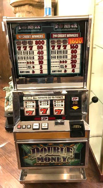"Double Money Slot Machine: "Double Money" slot machine that accepts quarters and bills. Was in working condition when arrived, but may need servicing or programming. There are small cracks in the veneer on the top as shown whic