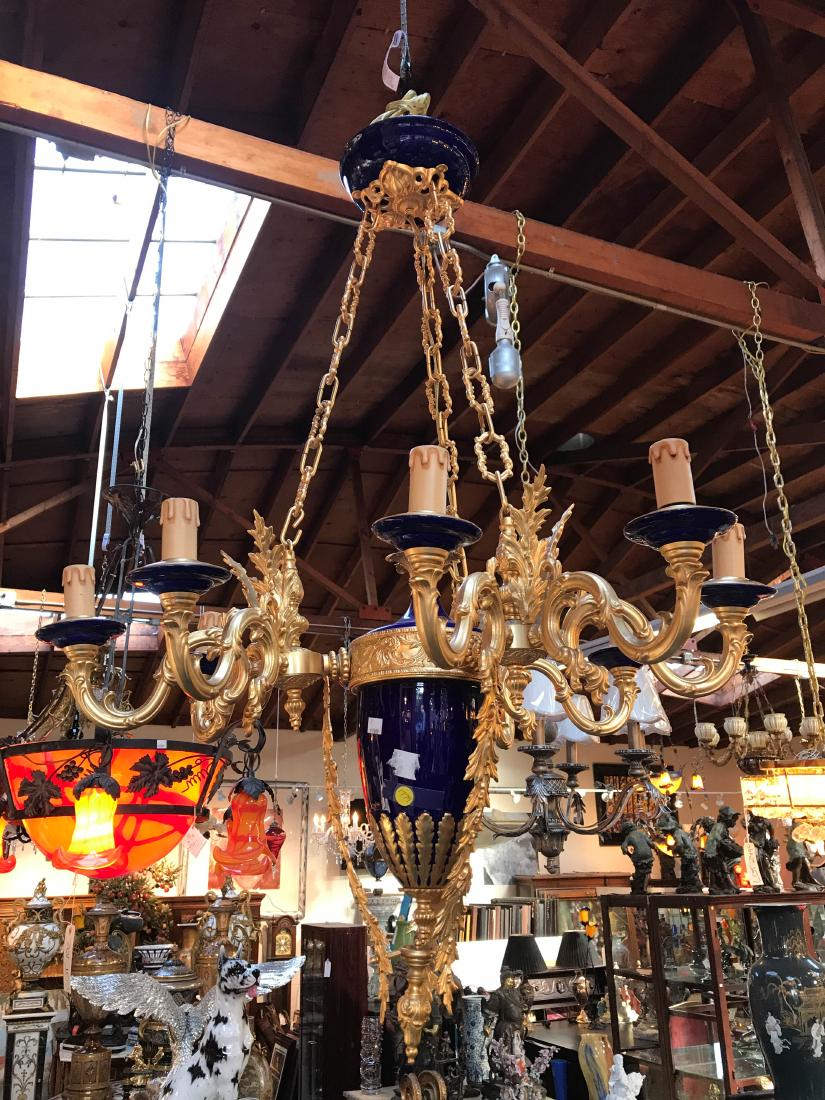 Cobalt Blue and White Porcelain, Bronze Chandelier: Cobalt blue and white porcelain chandelier with 24k gilded bronze accents with eight lights. Has good details with flowers. In good condition. Measures approx. 28"H x 33"W.