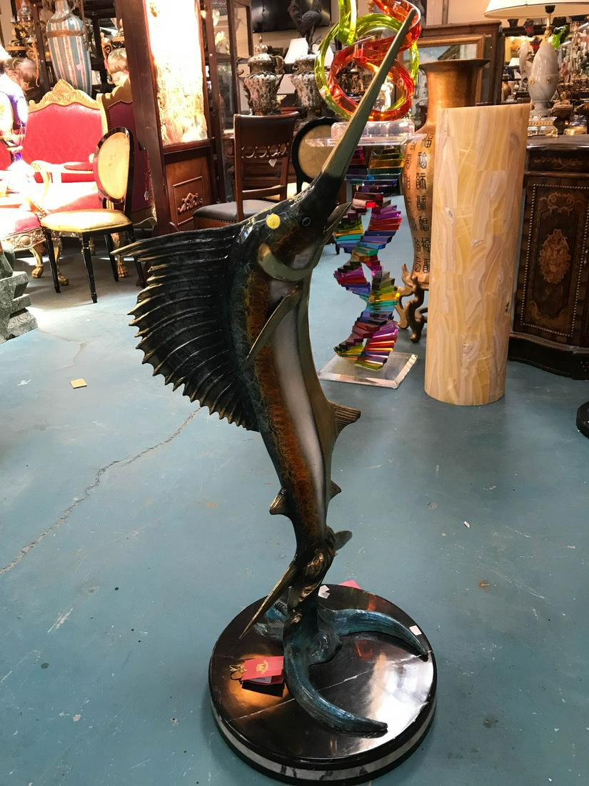 Bronze Swordfish Fountain/Statue: Multi-patinated bronze fountain/statue of a swordfish. Mountain on a black and white marble base. In good condition. Hose attachment is in the back. Measures approx. 44"H x 20"W x 17"D.
