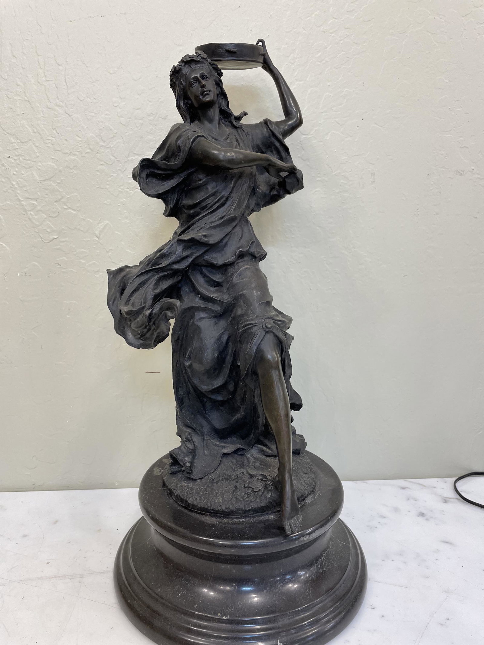Bronze Statue of Woman with Drum: Bronze biblical statue of woman with drum mounted on a solid black marble base. In good condition with good detail throughout. Measures approx. 23"H x 10" diameter on the bottom.