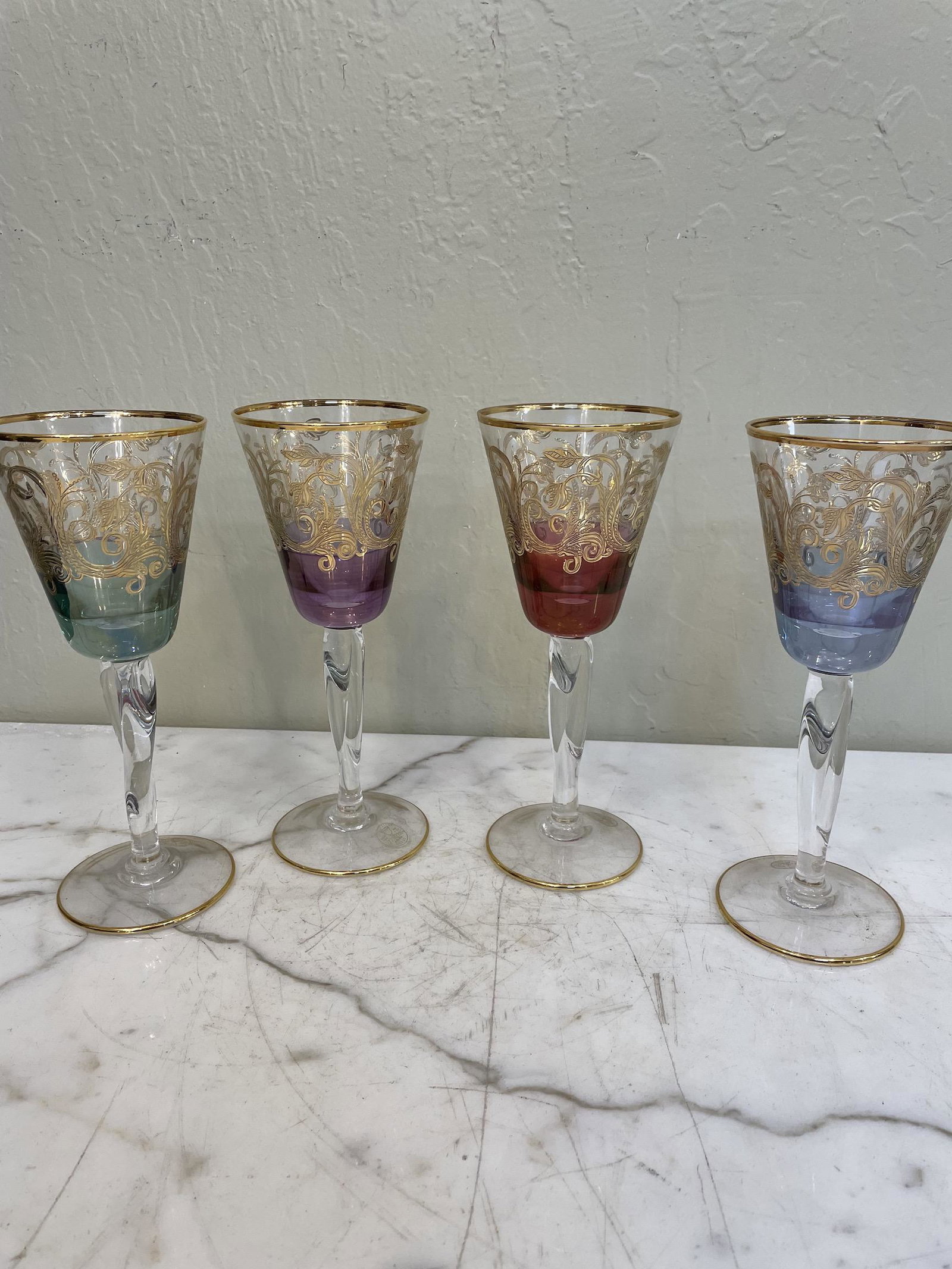 Set of 4 Multi-Colored Crystal Goblets: Set of four crystal goblets each a different color. Each has 24k gold leaf accents. In excellent, never used condition. Made in Italy. Each measures approx. 8.75"H x 3.5"W.
