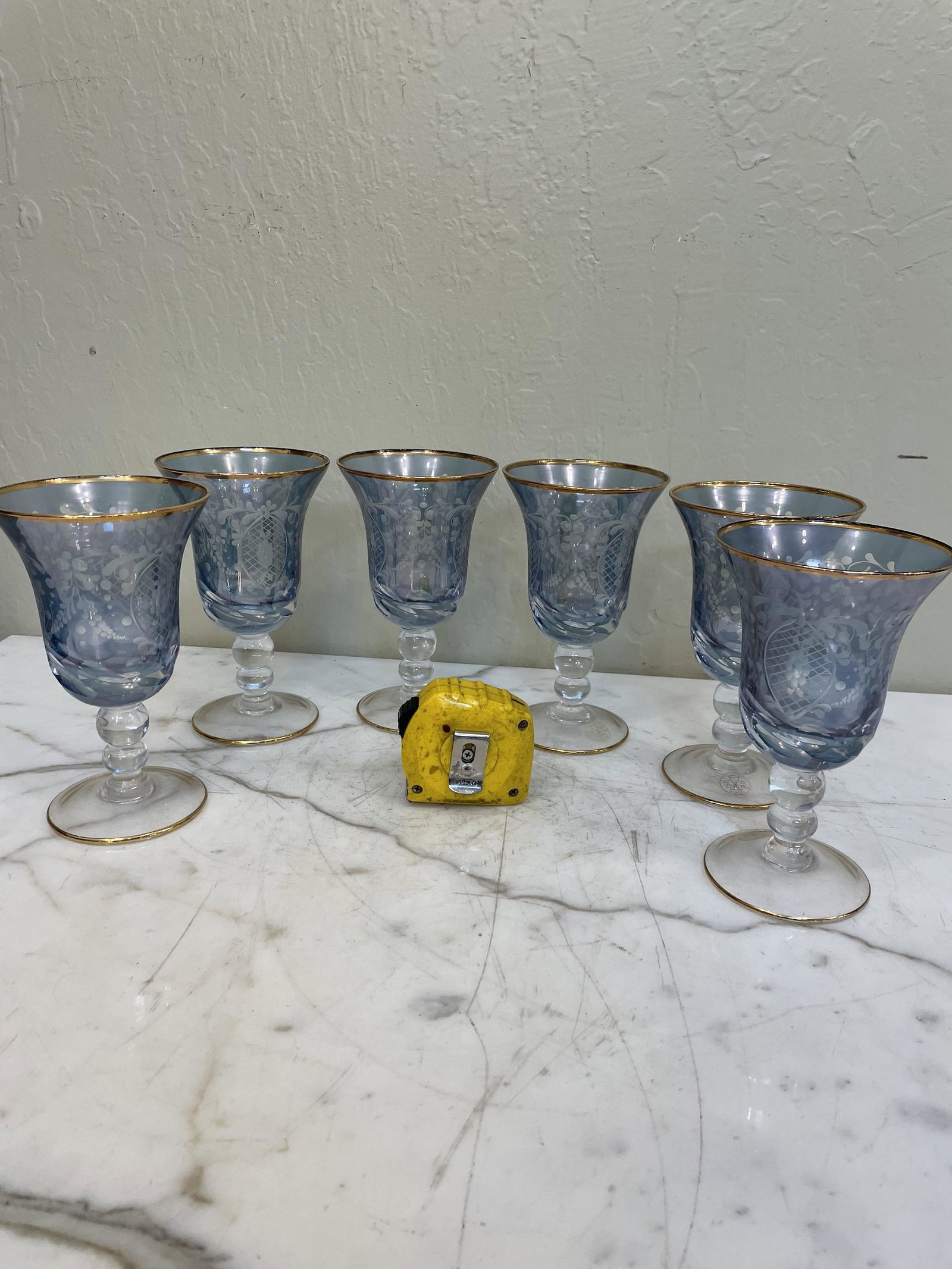 Set of 6 Blue Crystal, 24k Goblets: Set of six blue crystal goblets with 24k gold leaf accents and etched grape design. Made in Italy. In excellent, never used condition. Each measures approx. 6.5"H x 4"W.