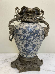 Vintage Porcelain and Bronze Vase: Vintage porcelain vase with detailed bronze accents and floral design. In good condition. From a local, private estate. Measures approx. 23"H x 17"W x 10"D.