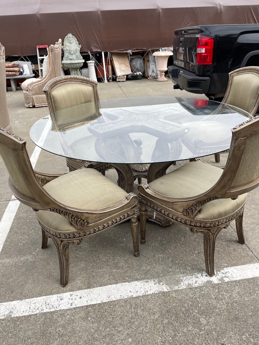 Dining Table Set with Four Chairs: Round glass top dining table with four chairs. Set is in very good condition and has never been used. Silvered wood throughout with excellent carved details. Table measures approx. 30"H x 60" diameter