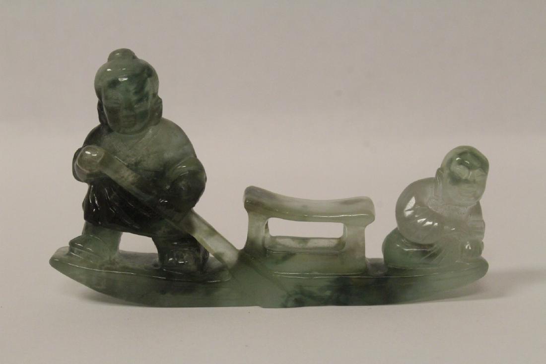 A jade like stone carving depicting 2 men on boat (1 of 10)
