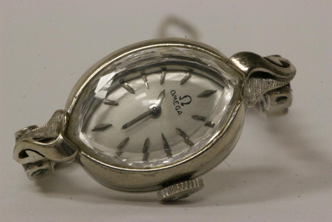 Lady's 14K W/G Omega wrist watch with 14K band: Lady's 14K W/G Omega wrist watch attached to a 14K W/G band, wt. 14.8gm