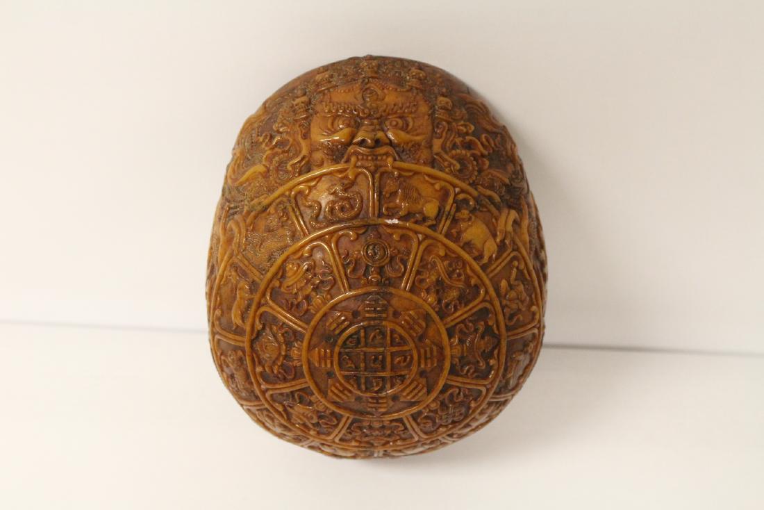 A rare Tibetan antique skull: A rare Tibetan antique skull elaborately carved with religious symbols in relief, 7"x5.8"x3"
