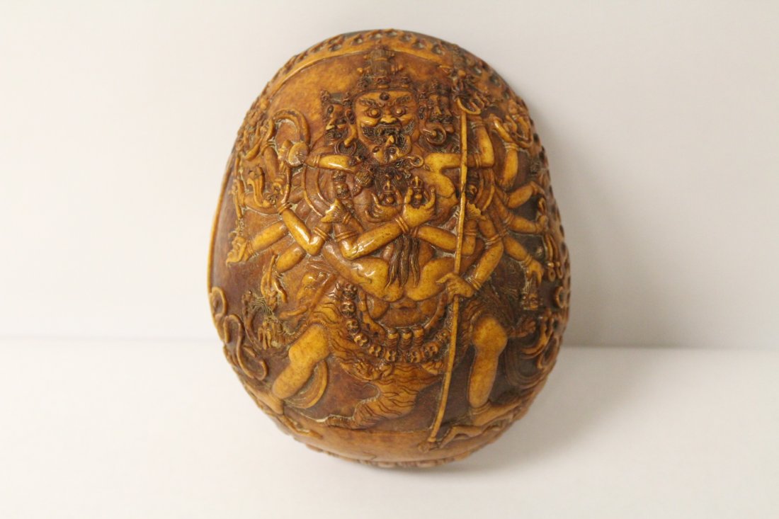 An important Tibetan antique carved skull: An important Tibetan antique skull with elaborate carving to depict portrait of Deity. 6.9" X 5.5" X 2.5"