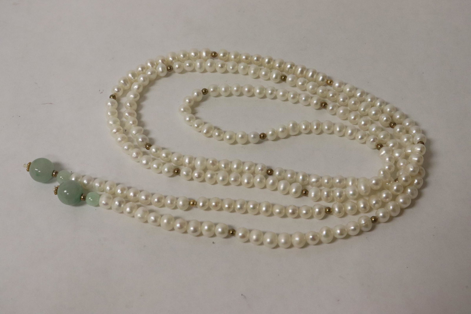 A freshwater necklace with jadeite bead finish: A freshwater (0.25"dia) necklace with jadeite bead (0.4"dia(2), 0.25"dia(2)) finish