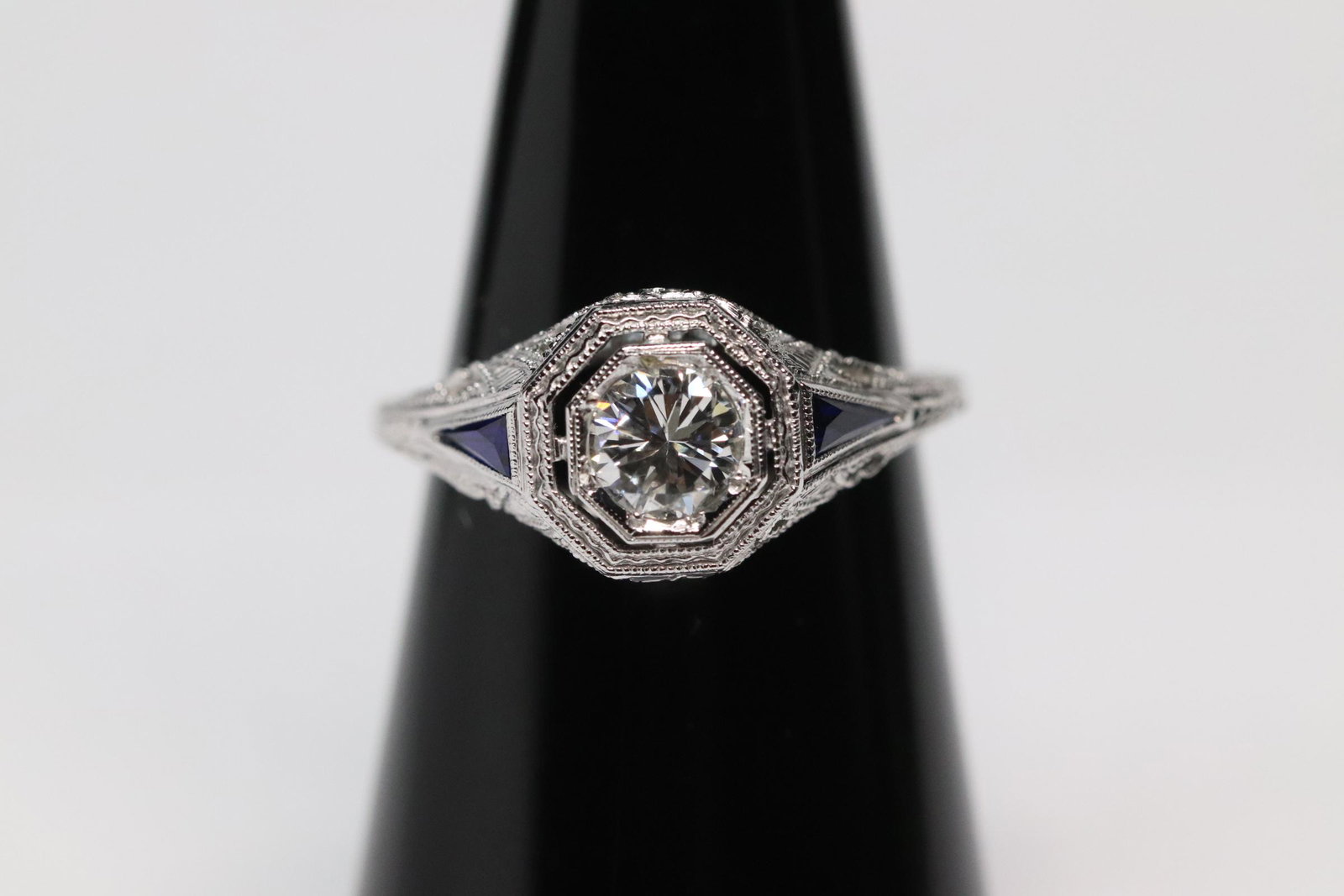 Beautiful art deco 18K diamond ring: Beautiful art deco 18K diamond ring, center a gem quality diamond (VS/VVS, G/H), wt. approx 0.68ct, accented by 2 triangular blue stones, size 6