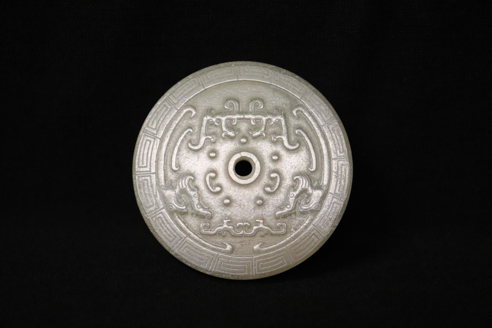 A finely carved Chinese white jade disc: A finely carved Chinese white jade disc, 0.18"x2.2"dia