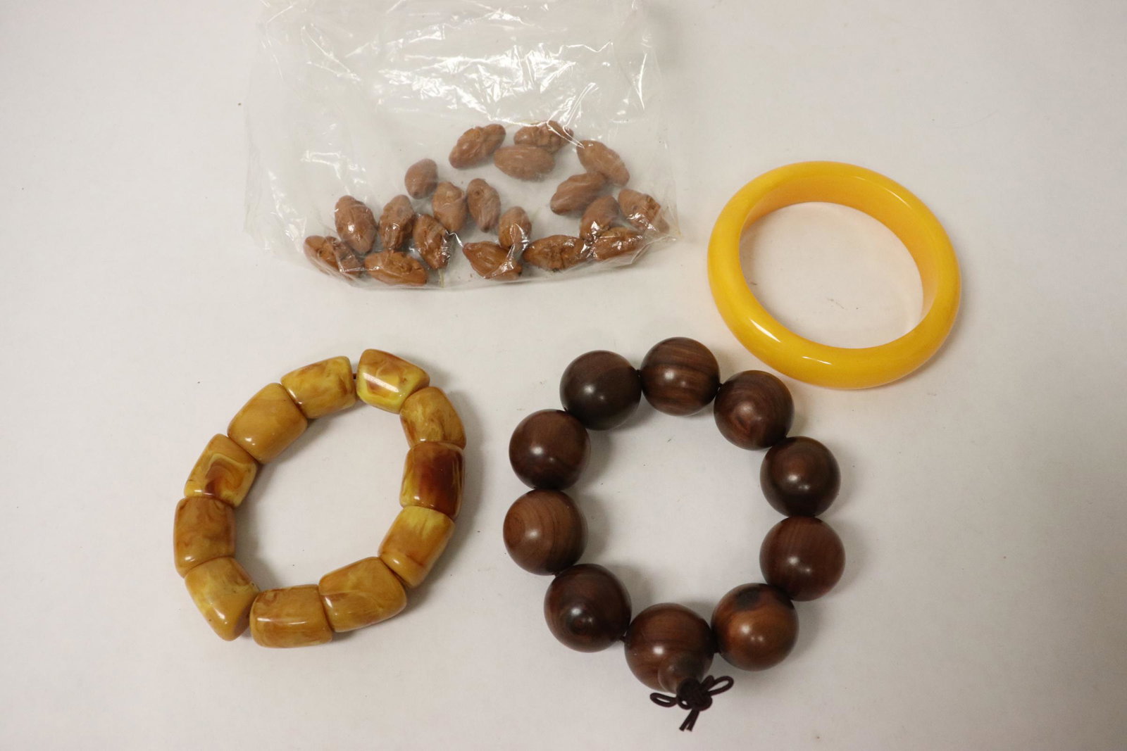 3 bracelets and group of loose carved nut(?) beads: 3 bracelets (0.95"dia, ~0.9"x0.65"dia, 0.65"x3.4"dia) and group of loose carved nut(?) beads (0.93"x0.45"dia)