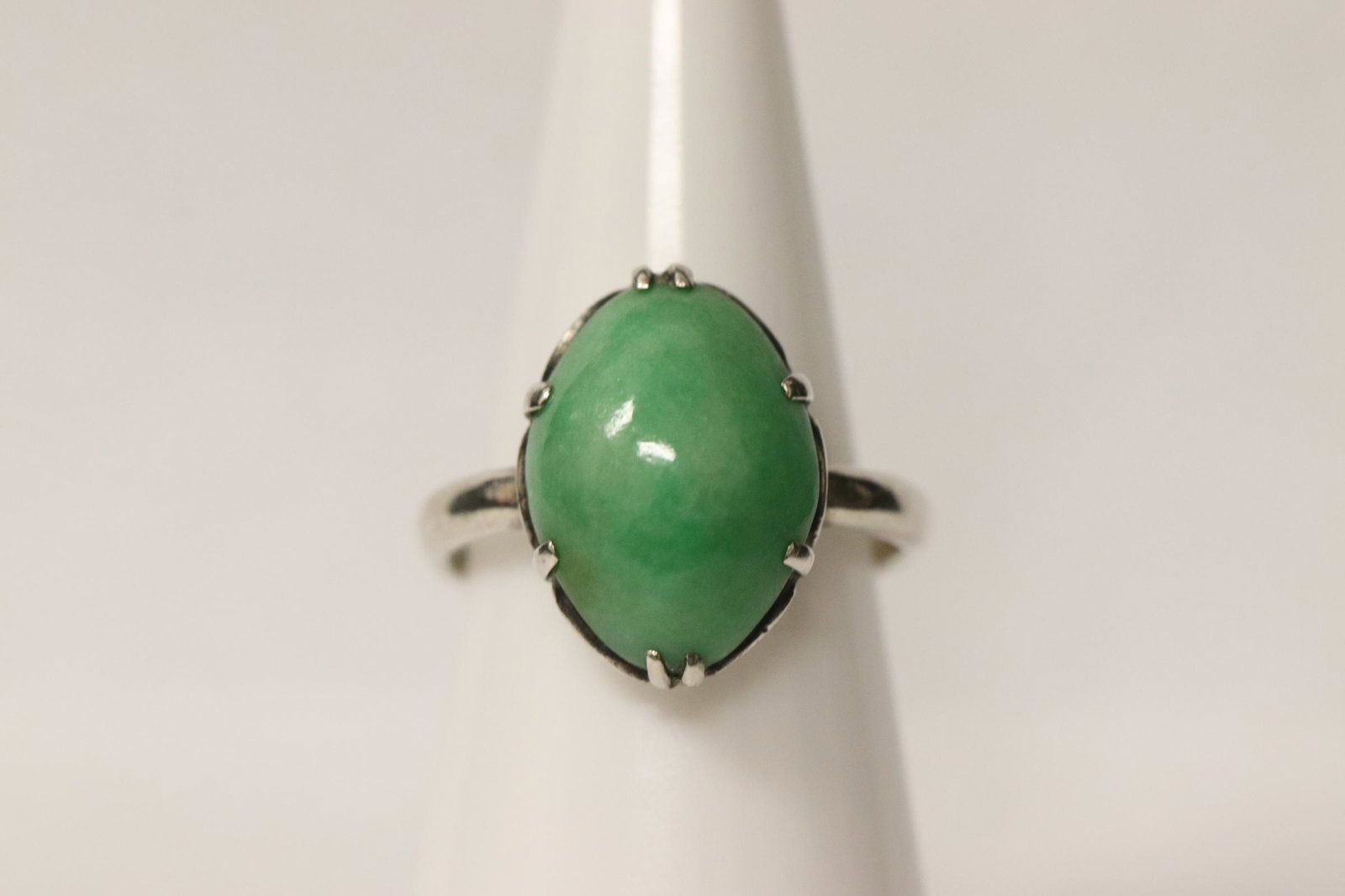 Chinese 19th/20th century jadeite silver ring: A fine Chinese 19th/20th century silver ring, center a natural color uniform apple green jadeite cabochon measures 15.5x11.2x5mm, size 5.4