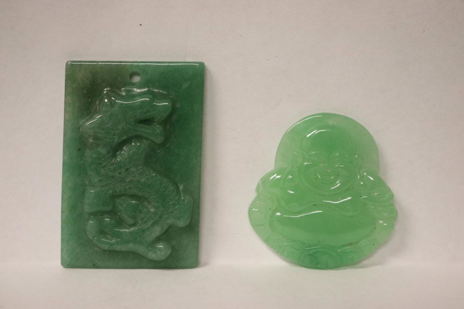 A jadeite Buddha and a jadeite like plaque: A jadeite Buddha (1.85"x1.75"x0.2") and a jadeite like plaque (2.38"x1.6"x0.33"), edge bruse