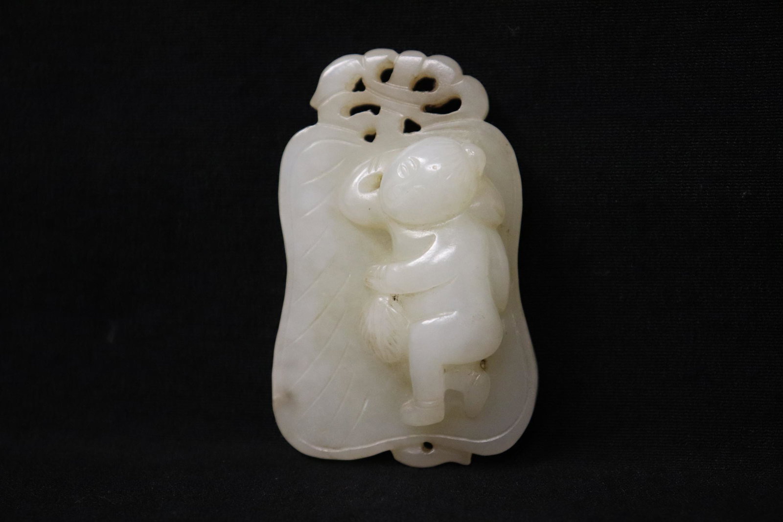 A beautiful white jade carved fan shape plaque: A beautiful white jade carved fan shape plaque decorated with figure motif in relief, 2.3"x1.45"x0.63"